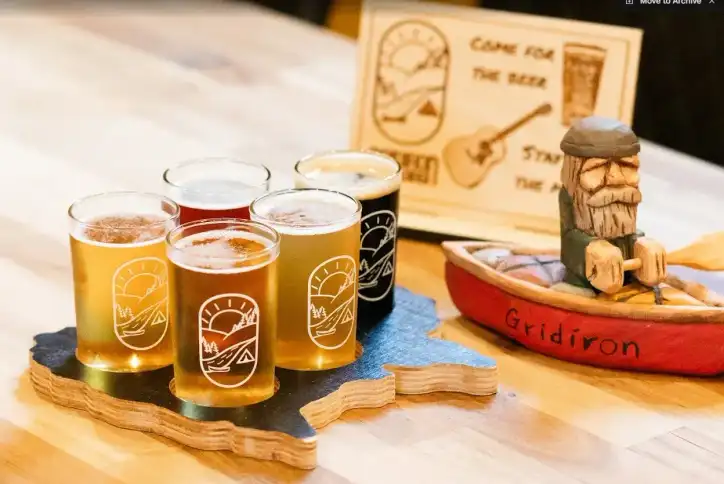 A flight of Gridiron beers on a wooden NB-shaped board
